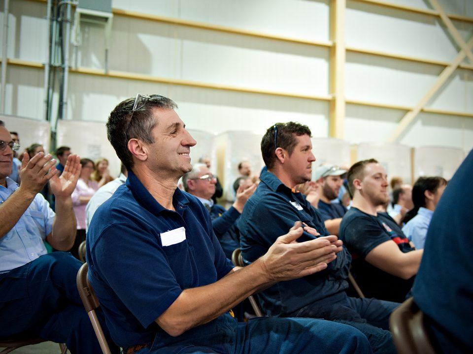 Employees applauding at company meeting